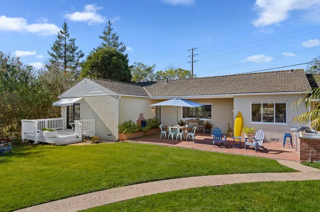 a view of a house with backyard sitting area and garden