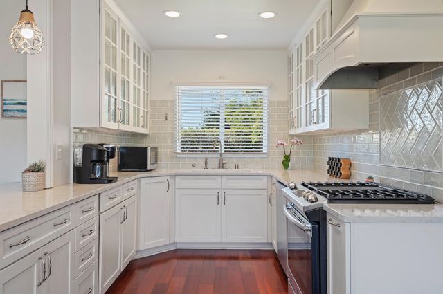 a kitchen with granite countertop a sink a window stainless steel appliances and cabinets