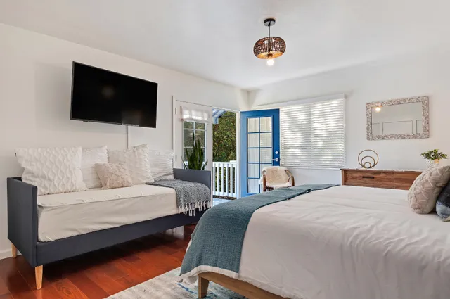 a bedroom with a bed a flat screen tv and a couch