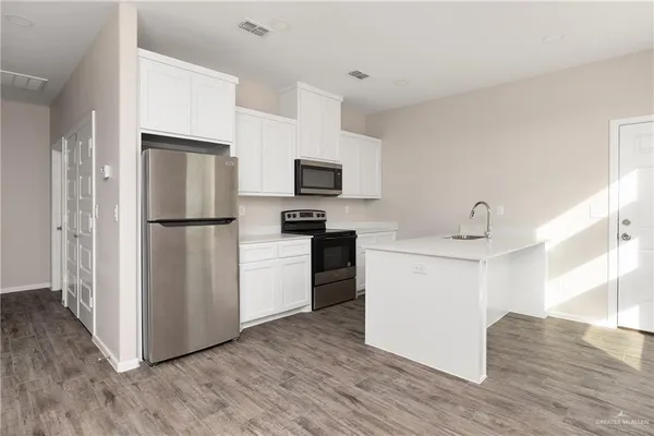 a kitchen with a refrigerator stove and wooden cabinets