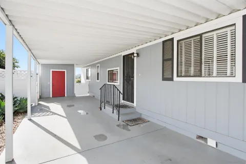 a view of a swimming pool with a patio and wooden fence