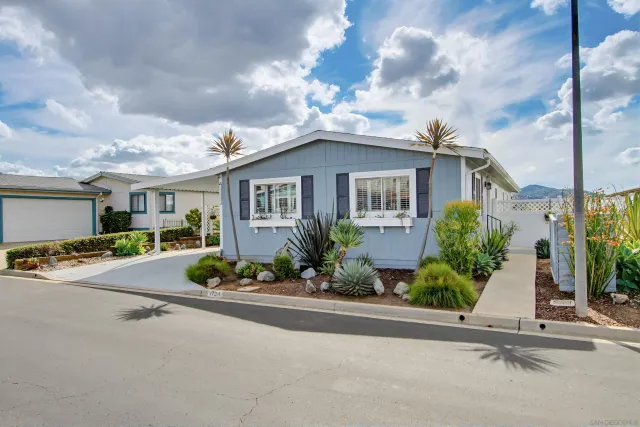 a view of a house with a cars park side of a road