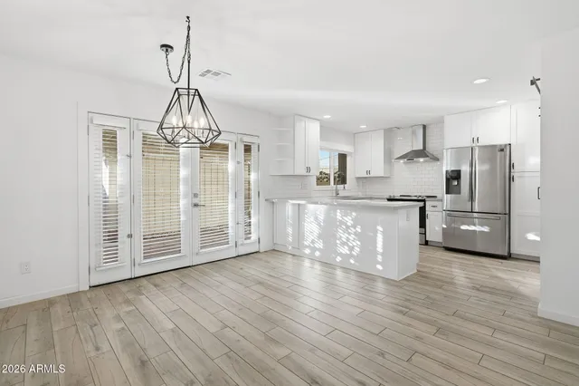 a view of a kitchen with stainless steel appliances wooden floor and a window