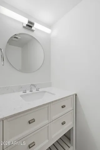 a bathroom with a sink vanity and a mirror