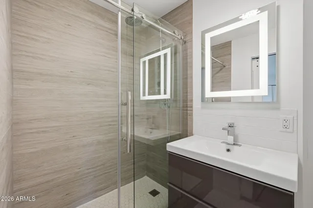 a bathroom with a sink a mirror and shower