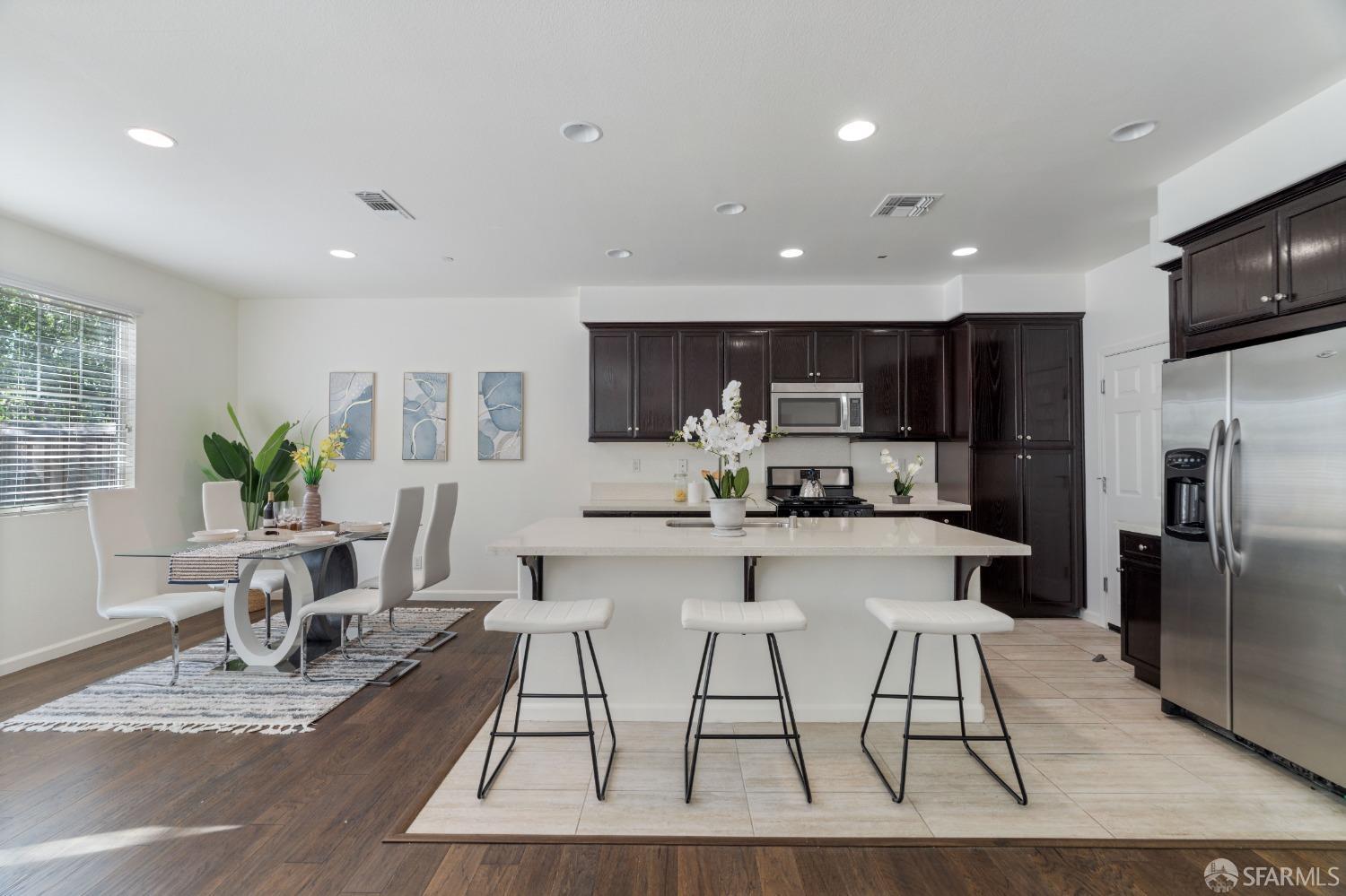 324 MacArthur Way Brentwood, CA 94513 - Photo 11 of 45 a kitchen with stainless steel appliances kitchen island granite countertop a refrigerator top oven a sink dishwasher and a dining table with wooden floor