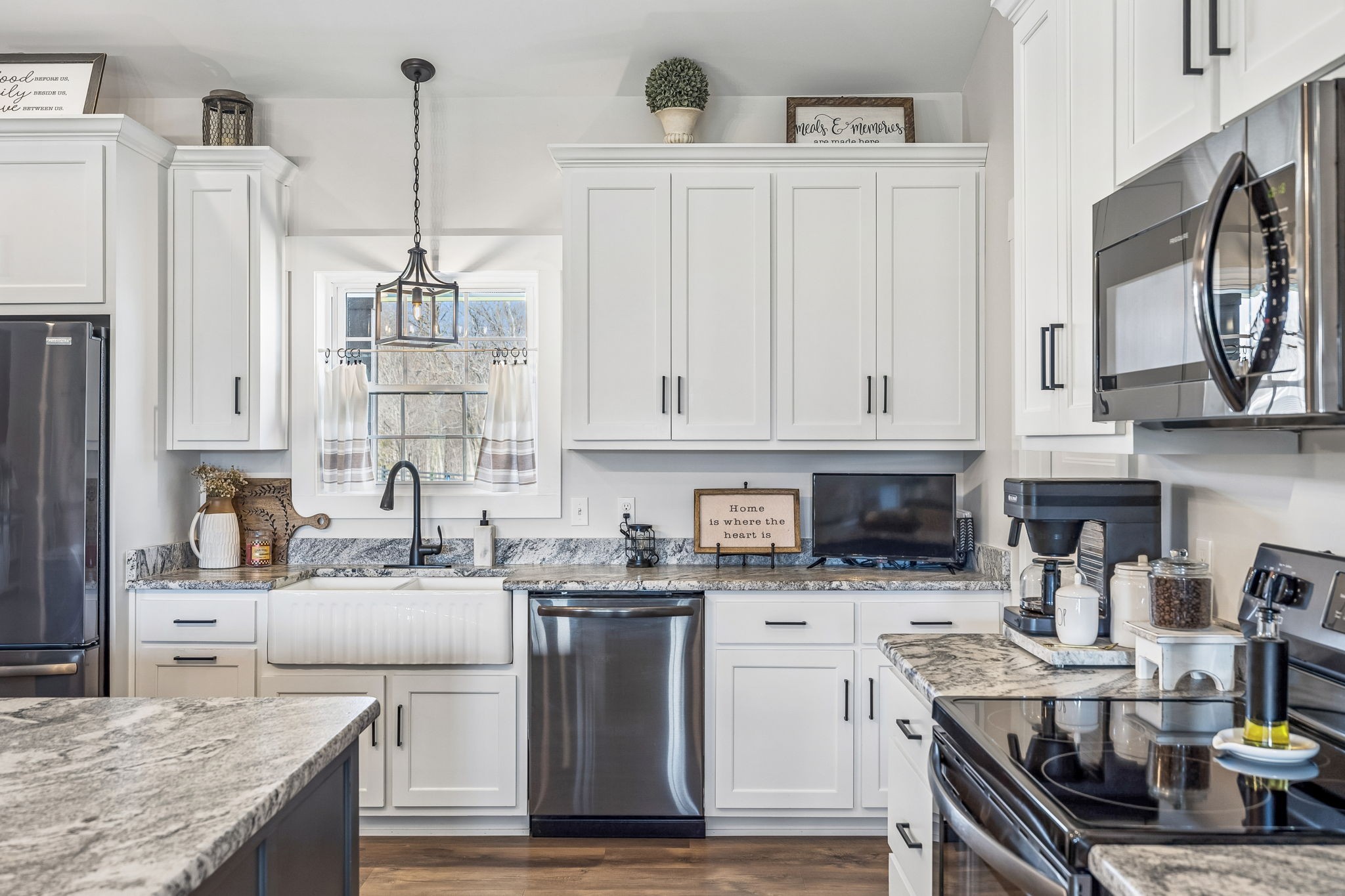 1869 Taurus Farm Road Lafayette, TN 37083 - Photo 16 of 60 a kitchen with stainless steel appliances kitchen island granite countertop a sink a stove and white cabinets