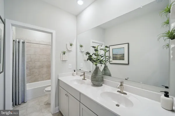 a bathroom with a tub shower sink and mirror