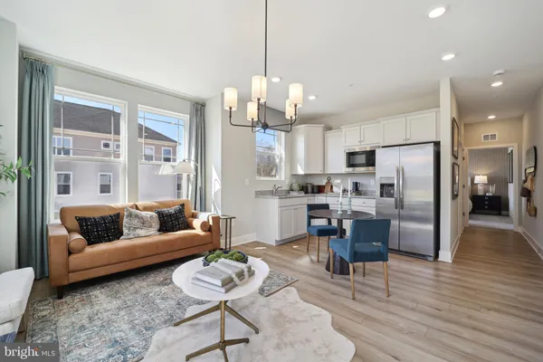 a living room with furniture kitchen and a chandelier