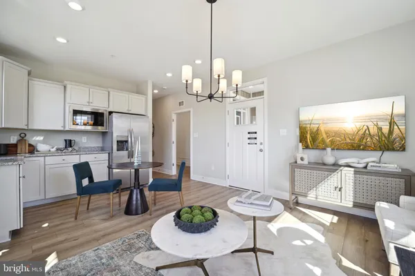 a living room with furniture kitchen view and a chandelier