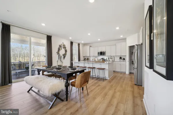a living room with stainless steel appliances granite countertop furniture wooden floor and a large window