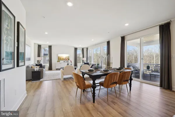 a living room with furniture wooden floor and a large window