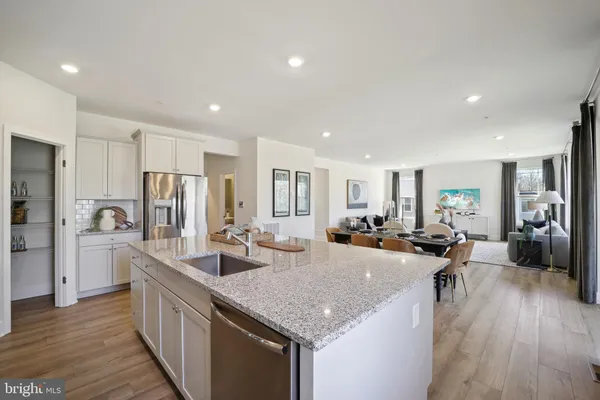 a kitchen with sink refrigerator and wooden floor