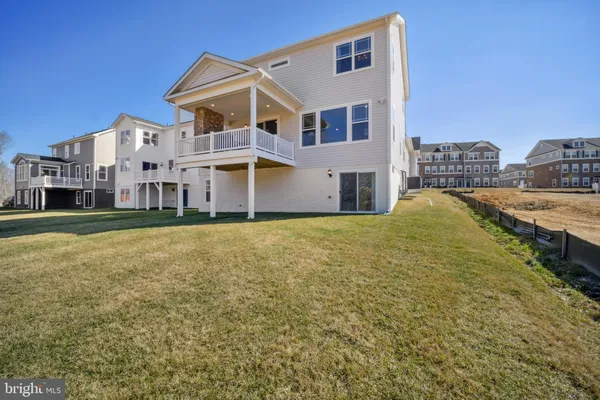 a view of a big house with a big yard and large trees