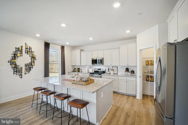 a kitchen with refrigerator cabinets dining table and chairs