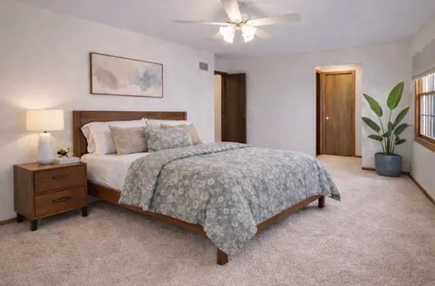 a spacious bedroom with a bed and a chandelier