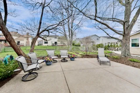a view of a patio with a table and chairs under a large tree