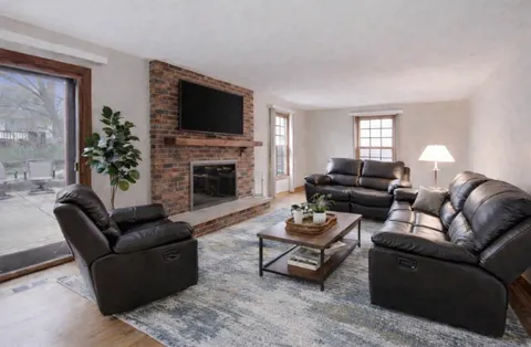 a living room with furniture a flat screen tv and a fireplace