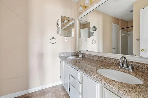 a bathroom with a granite countertop sink and a mirror