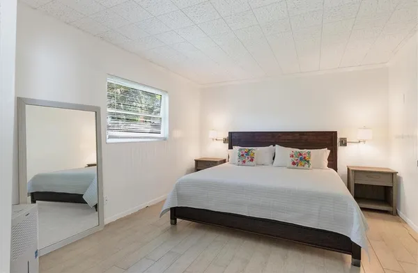 a bedroom with a bed and a mirror