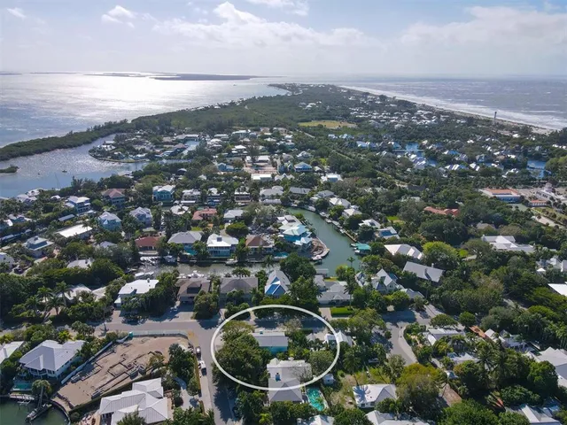 an aerial view of residential houses with outdoor space and trees