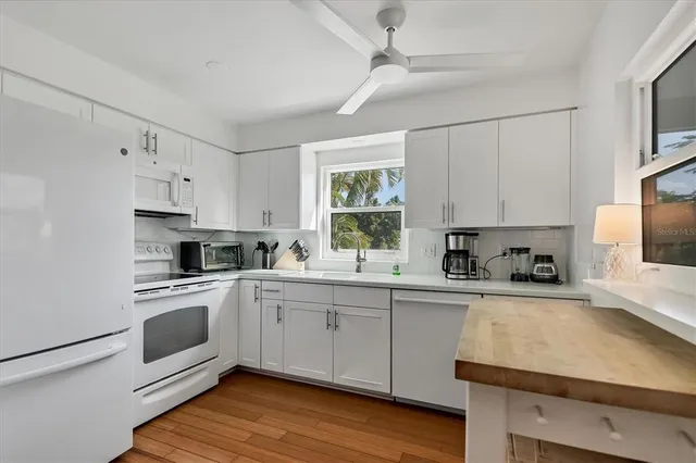 a kitchen with cabinets appliances a sink and a window