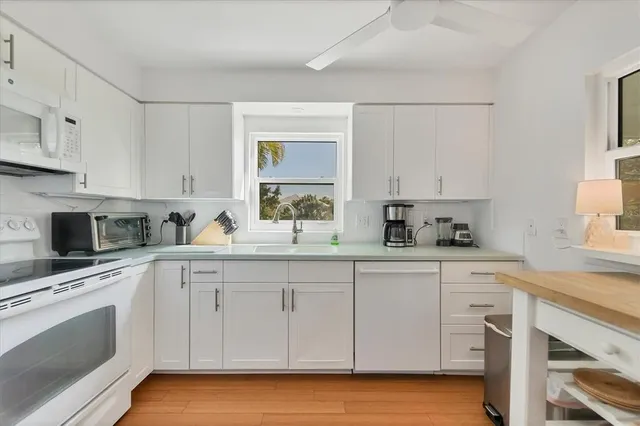 a kitchen with white cabinets stainless steel appliances and sink