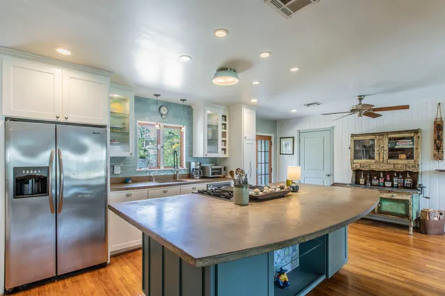a kitchen with stainless steel appliances granite countertop a sink a stove and a refrigerator