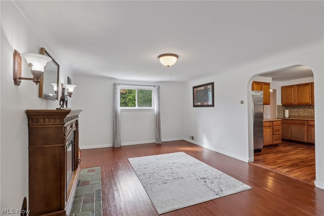 4188 Manchester Road Perry, OH 44081 - Photo 12 of 41 Wood-finish flooring throughout, featuring a fireplace with a decorative mantel and tiled hearth