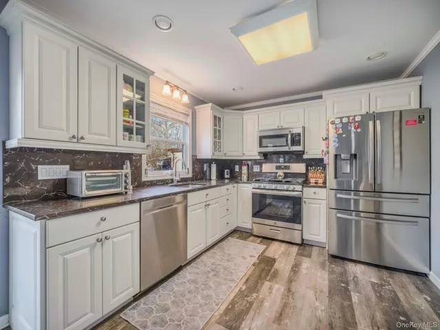 a kitchen with granite countertop appliances cabinets and a sink