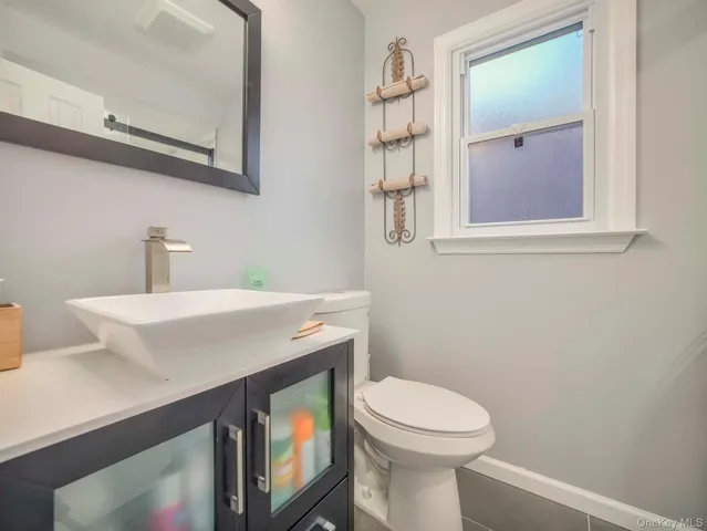 a bathroom with a sink a toilet and mirror
