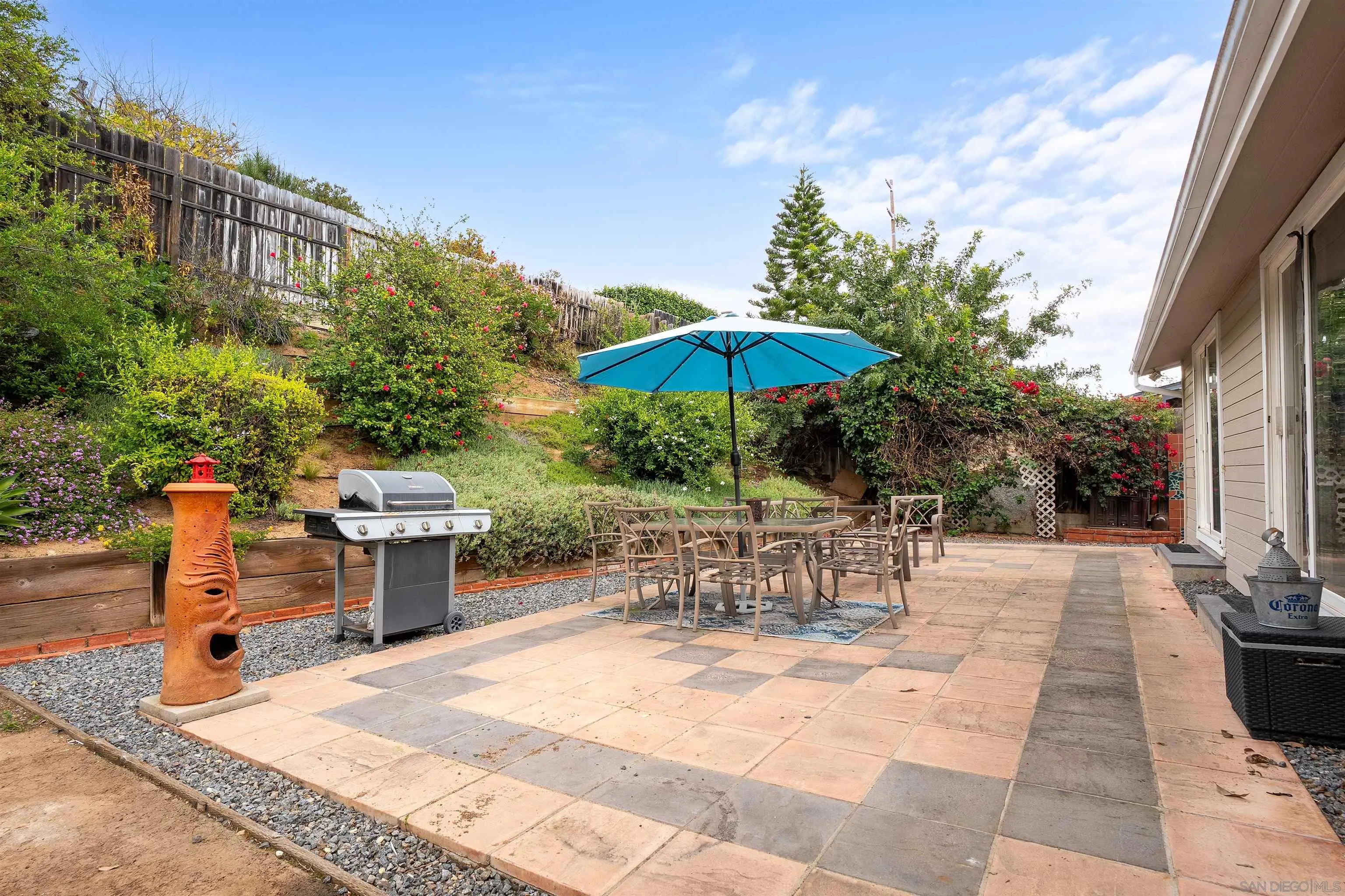 12452 Janet Kay Way El Cajon, CA 92021 - Photo 25 of 30 a view of a patio with a dining table and chairs under an umbrella with a barbeque