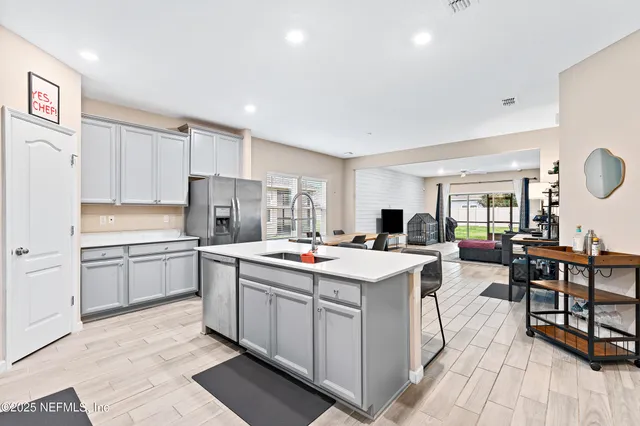 a kitchen that has a lot of cabinets in it with stainless steel appliances granite countertop a stove and a refrigerator