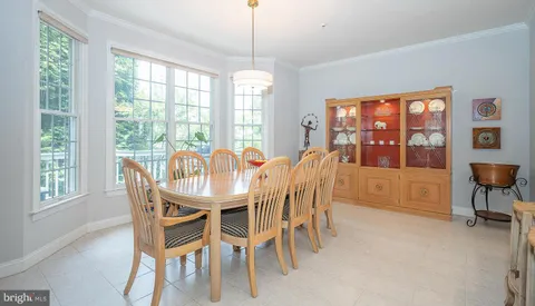 a dining room with furniture a chandelier and wooden floor