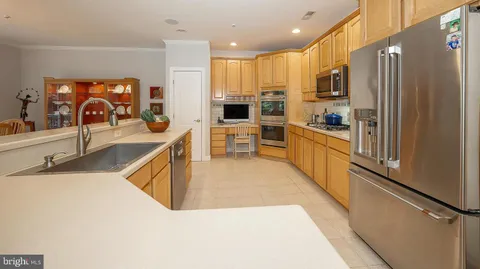 a kitchen with stainless steel appliances granite countertop a sink and a refrigerator