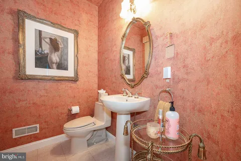 a bathroom with a toilet a sink and mirror