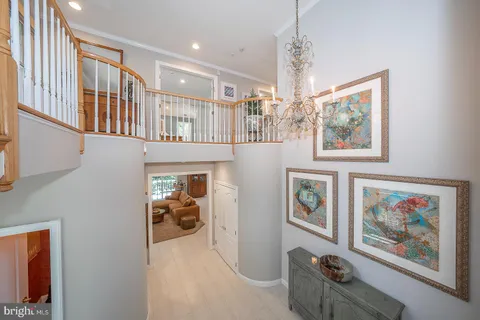 a view of hallway with furniture and a chandelier