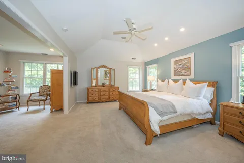 a spacious bedroom with a bed and a chandelier