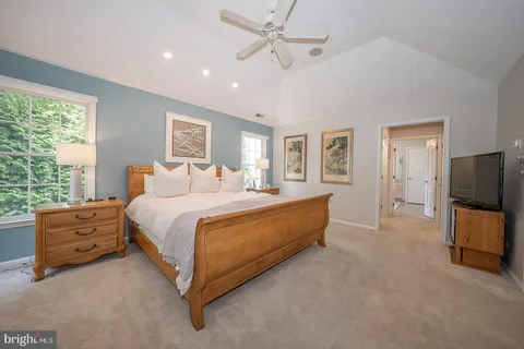 a spacious bedroom with a bed and a flat screen television