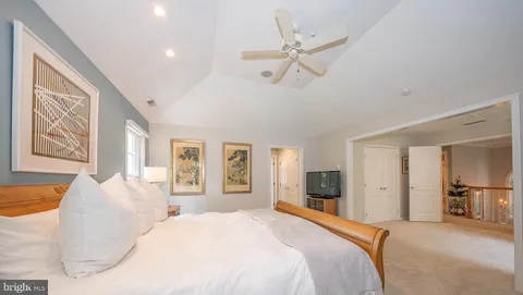 a spacious bedroom with a large bed and a chandelier