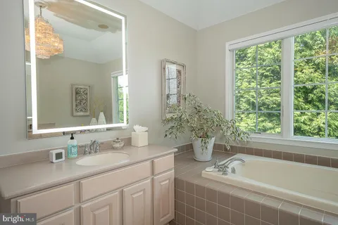 a bathroom with a tub a sink and a window