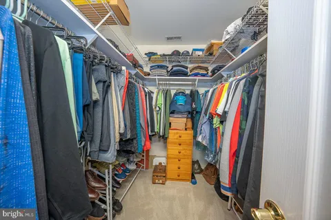 a view of walk in closet with clothes