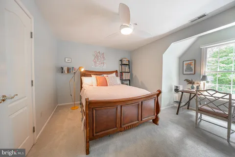 a bedroom with a bed and a table chair