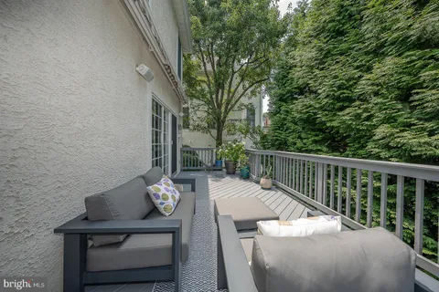 a balcony with wooden floor table and chairs