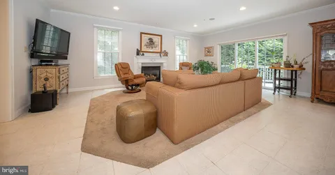 a living room with furniture a flat screen tv and a window