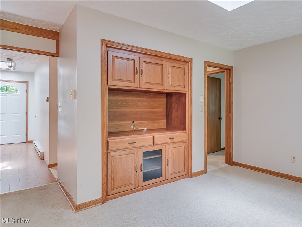 3087 Baughman Road Clinton, OH 44216 - Photo 12 of 24 Unfurnished living room featuring a baseboard heating unit, light carpet, and a textured ceiling