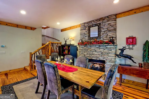 a kitchen with stainless steel appliances granite countertop a table chairs and a refrigerator
