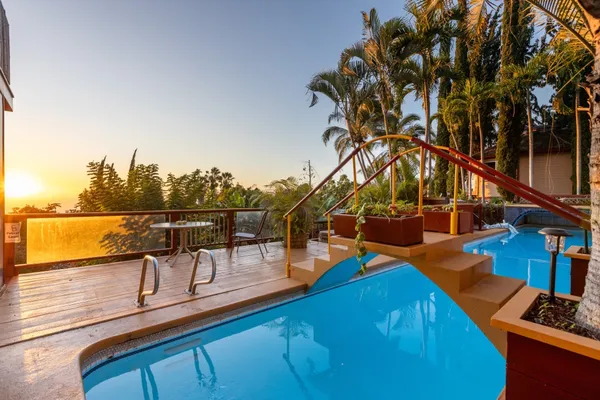 a view of a ocean with boats and trees in the background