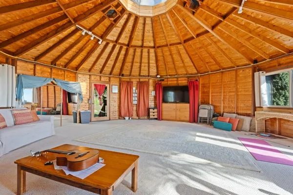 a backyard of a house with sofas table and chairs