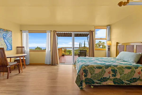 a bedroom with a bed and large windows